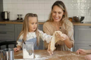une maman qui prepare la pate gateau avec sa petite fille